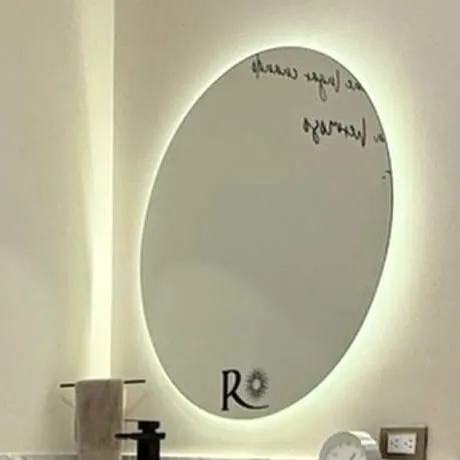 The lit round mirror of a treatment room, with the Radanta R.
